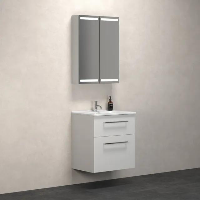 Vitt badrumsmöbelset med spegelskåp och två lådor, monterat på vägg.