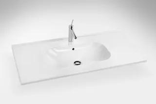 Vit rektangulär tvättställ med en kran och ett avrinningshål i mitten.