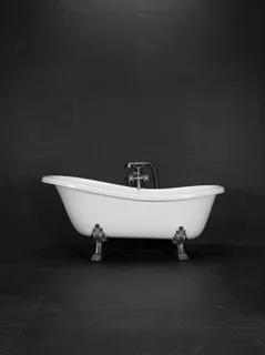 Vitt badkar med kromtassar, placerat mot en mörk bakgrund. Badkaret har en hög kran monterad i mitten.