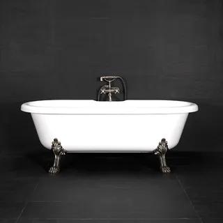 Vitt fristående badkar med kromtassar mot en svart kakelvägg.