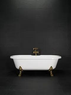 Frittstående vit badkar med antikmässingsfärgade tassar mot en mörk bakgrund.