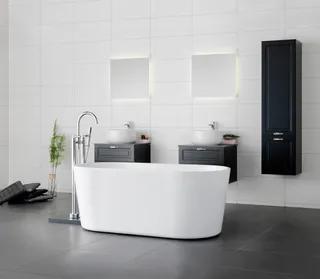 Modernt badrum med fristående vit badkar, dubbla handfat på svarta skåp, och väggmonterat högskåp.