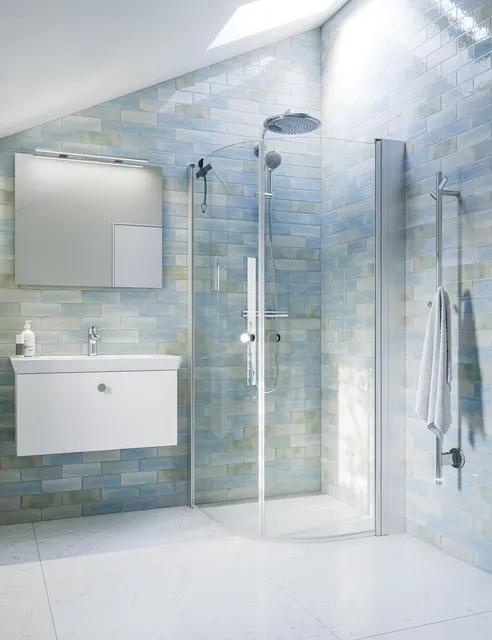 Duschhörn i glas, vinkel, ljust badrum med kommod, handfat och handdukar.