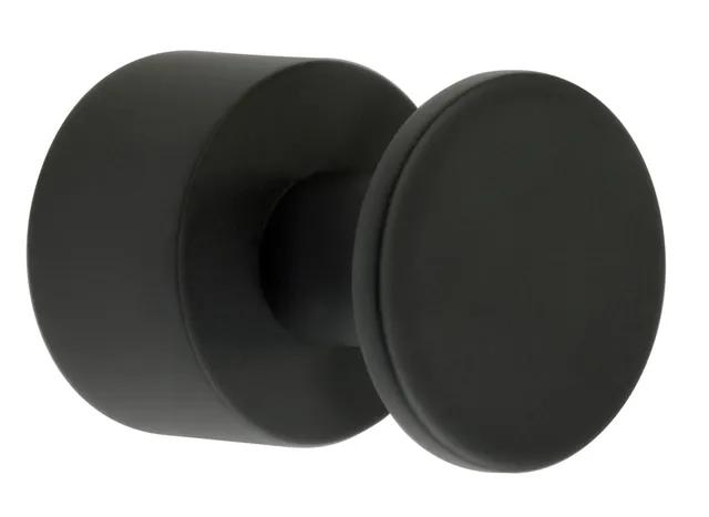 Svart, rund krokliknande föremål i matt finish, monterat på en cirkulär bas.