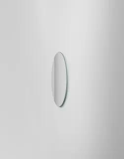 Rund väggmonterad spegel, på en ljusgrå vägg.