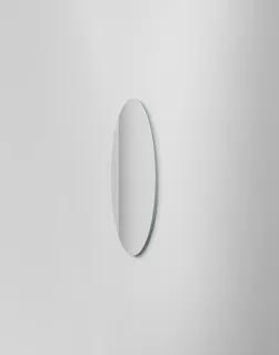 Rund spegel med mjuk belysning bakaom på en vit vägg.