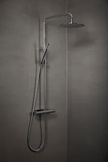 Duschset med regnduschhuvud och handdusch i krom mot grå vägg.