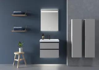 Modernt badrum med grått skåp, spegel med belysning och hylla med vikta handdukar mot en blå vägg.